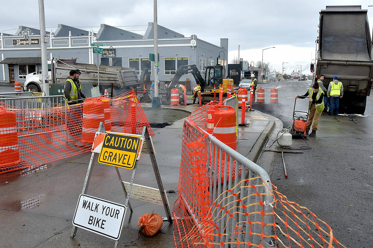 A paving crew from Lakeside Industries replaces pavement on the Waterfront Trail and the entrance to the Port Angeles City Pier parking lot on Wednesday as part of a project to improve sidewalks and storm water drainage around the site. The project is expected to be substantially completed and the parking lot reopened by mid-March. (Keith Thorpe/Peninsula Daily News)