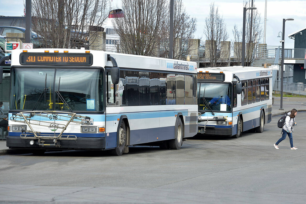 A pair of Clallam Transit buses sit at The Gateway Transit Center in Port Angeles in preparation for their fixed-route runs on Thursday. (Keith Thorpe/Peninsula Daily News)