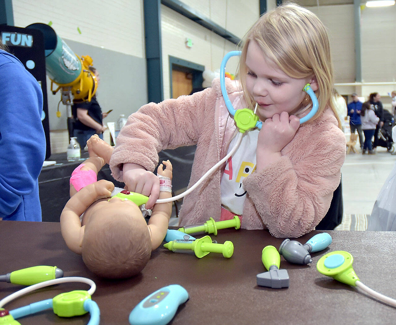 Skylar Sutherland, 5, of Port Angeles uses a toy stethoscope during a pretend examination of a doll at an information table set up by Olympic Medical Center’s New Family Services and Pediatrics departments during Saturday’s 35th annual Kids Fest at Vern Burton Community Center in Port Angeles. The event, hosted by Port Angeles Kiwanis, featured a variety of displays and information tables showcasing family and children’s services. Kids Fest also included numerous outdoor public safety displays organized by Clallam County Emergency Services. (Keith Thorpe/Peninsula Daily News)