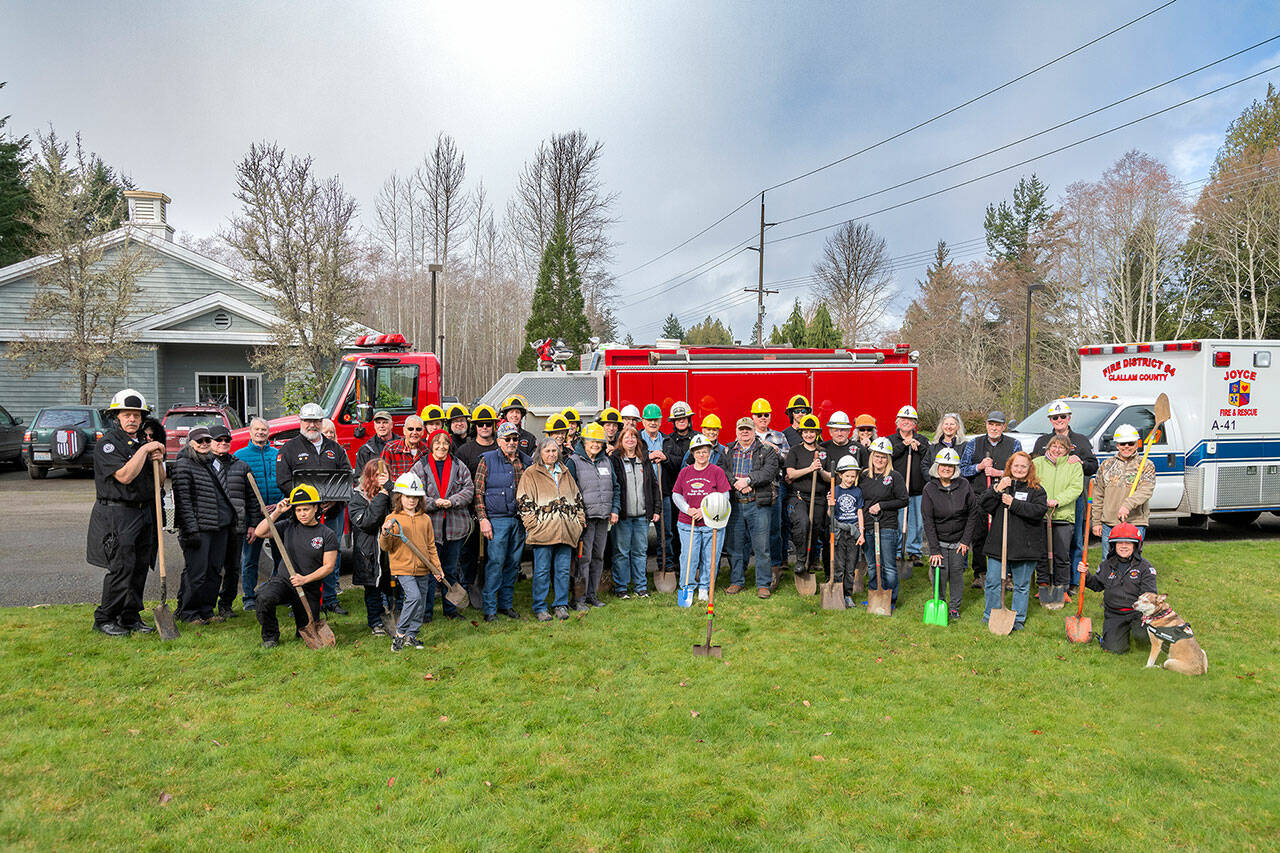 Joyce community, donors and Joyce Fire District members gather for a groundbreaking ceremony at the site of the new equipment bay building to be constructed at 51162 Highway 112 in Joyce. The shovel with the helmet on top is in memory of the late Terry Barnett, a former commissioner who was instrumental in the building project before he died. (Roger Mosley)