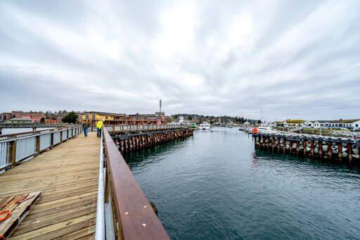 Matt Klontz with the Port of Port Townsend, in a yellow jacket, looks over the nearly completed south breakwater jetty at the entrance to Point Hudson Marina with Jacob Bates, an Orion employee, during a punch-list review on Wednesday. The jetty is expected to be finished next week. (Steve Mullensky/for Peninsula Daily News)