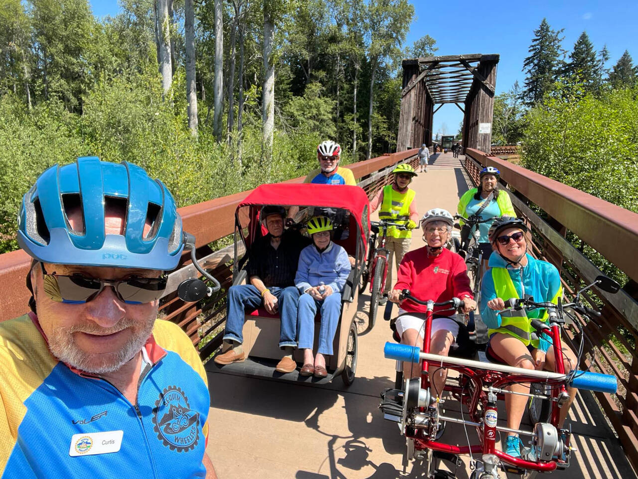 Sequim Wheelers, seen on the historic Railroad Bridge near the Dungeness River Nature Center, prep for a ride on the Olympic Discovery Trail. The nonprofit’s season begins in May, and it has an open house for potential new volunteers on April 20 at the River Center. It also has an orientation for new volunteers on April 25 at the River Center. (Sequim Wheelers)