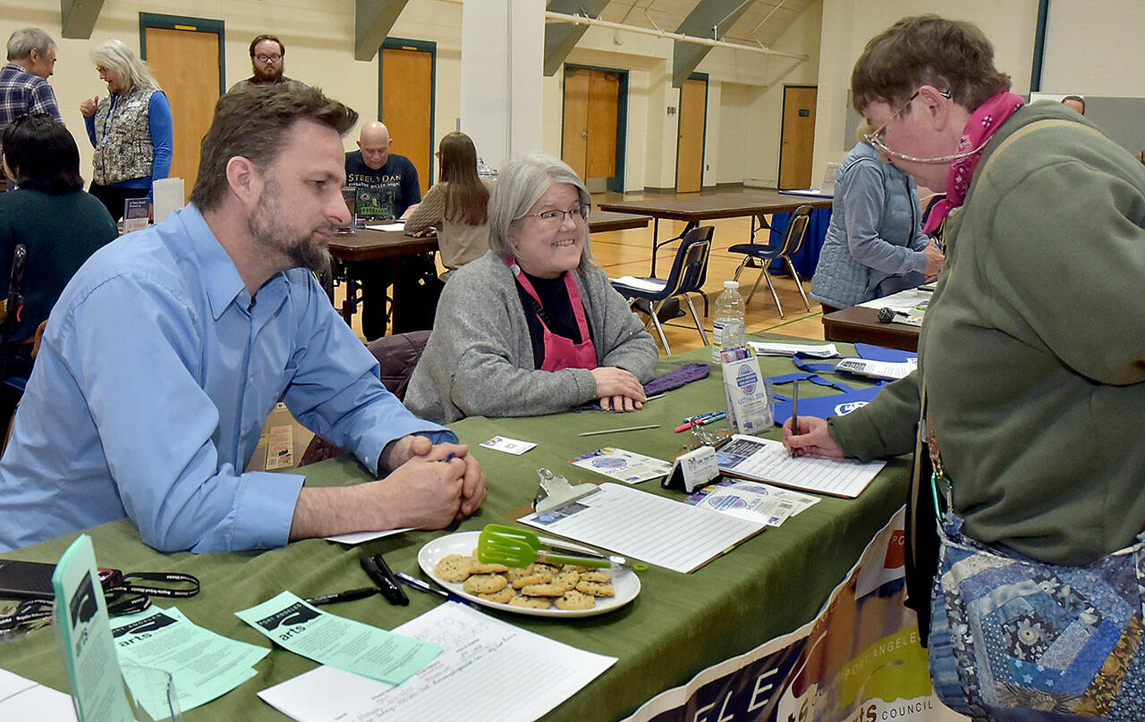 Amy DeQuay of Port Angeles, right, signs up for information at a table staffed by Christopher Allen and Mary Sue French of the Port Angeles Arts Council during a Volunteer Fair on Wednesday at Vern Burton Community Center in Port Angeles. The event, organized by the Port Angeles Chamber of Commerce, brought together numerous North Olympic Peninsula agencies that offer people a chance to get involved in their communities. (Keith Thorpe/Peninsula Daily News)