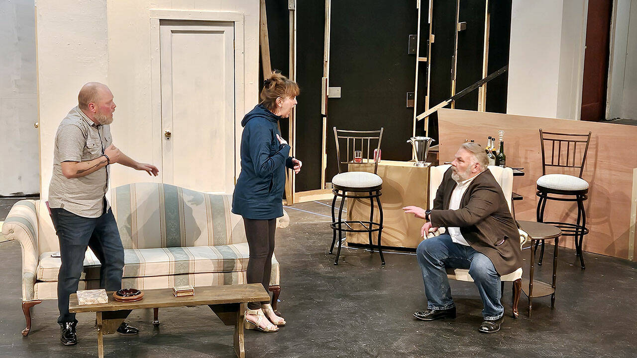 From left to right, Zach Wiedenhoeft, Rebecca Gilbert and Mark Valentine, all of Port Angeles, participate in a recent rehearsal on the unfinished set of “Rumors.”