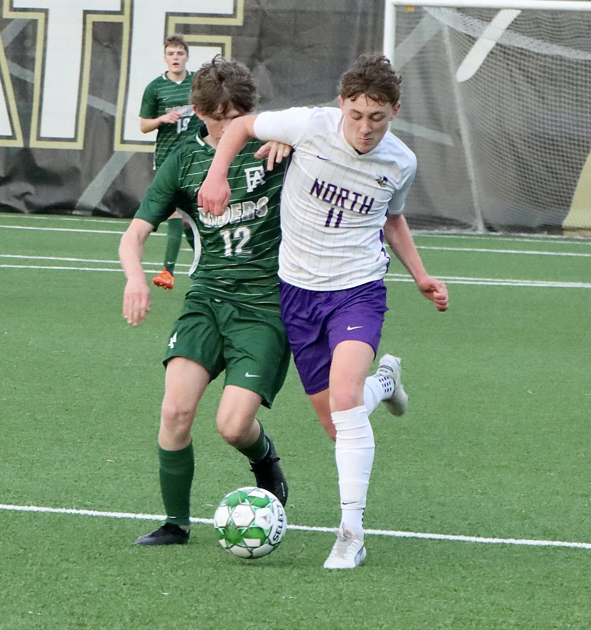 Port Angeles soccer player Cannon Wood (12) is elbowed out of the way by North Kitsap’s Ethan Peck (11) Friday night at Wally Sigmar Field at Peninsula College. (Dave Logan/for Peninsula Daily News).