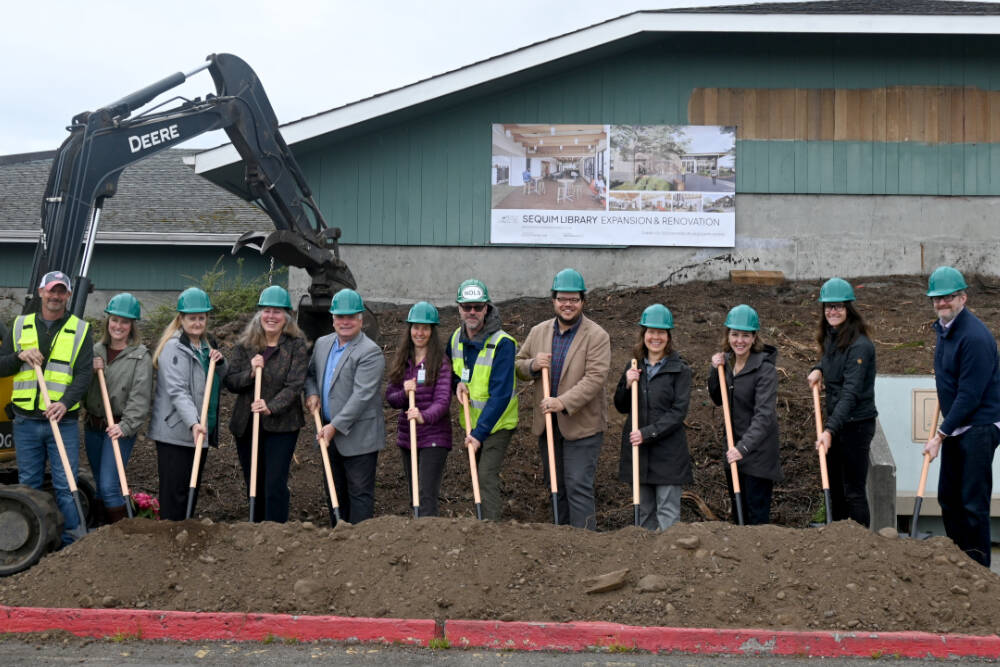 Staff from the North Olympic Library System (NOLS) join project partners at the groundbreaking of the Sequim Library expansion on Wednesday. Pictured, from left, are Kyle and Carrie Priest, owners of Hoch Construction; NOLS board members Jennifer Pelikan; Cyndi Ross and chair Mark Urnes; NOLS collection services manager Erin Shield, facilities manager Brian Phillips, executive director Noah Glaude and Sequim Library manager Emily Sly; Marlo Dowell of Acila Consulting; and Pia Westen and Adam Hutschreider of SHKS Architects. (Michael Dashiell/Olympic Peninsula News Group)