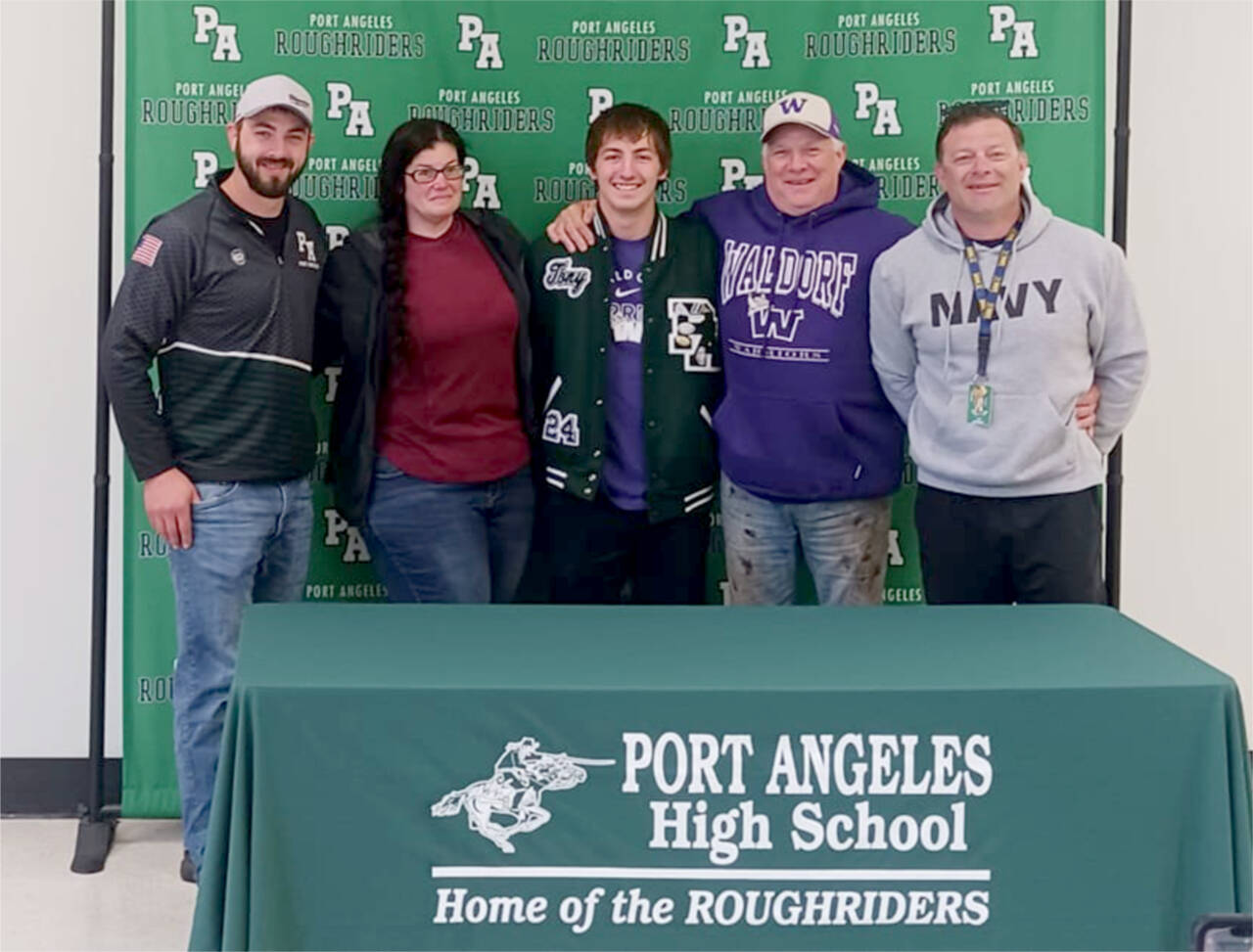 Port Angeles’ Tony McMahan surrounded by coaches and family as he signed to wrestle for Waldorf University in northern Iowa. From left, are, head coach Brian Cristion, mother Sarah McMahan, Tony McMahan, father Mike McMahan and assistant coach Rob Smith. (Pierre LaBossiere/Peninsula Daily News)