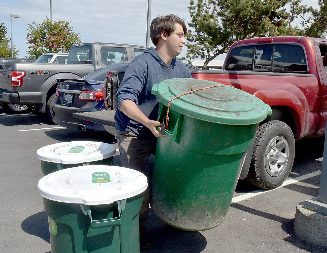 Benji Astrachan of Sisterland Farms collects bins of unwanted food collected by restaurants at the Wharf in Port Angeles. (Keith Thorpe/Peninsula Daily News)