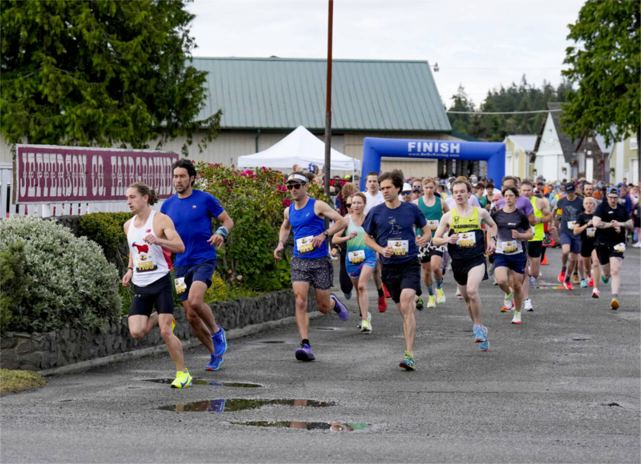 Steven Mullensky/for Peninsula Daily News Port Townsend’s Seamus Fraser, in white tank top, leads the pack at the beginning of the 44th annual Rhody Run held Sunday in Port Townsend. Fraser went on to win the 10K.