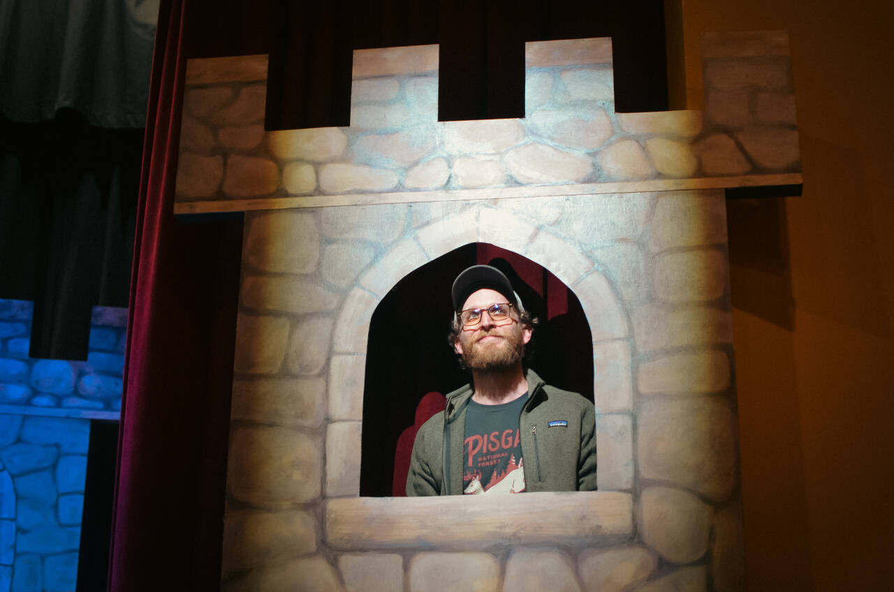 Actor Matt Forrest, who portrays Lancelot in the upcoming production of “Spamalot,” gazes out from a castle window at Olympic Theatre Arts on May 15. (Elijah Sussman/Olympic Peninsula News Group)