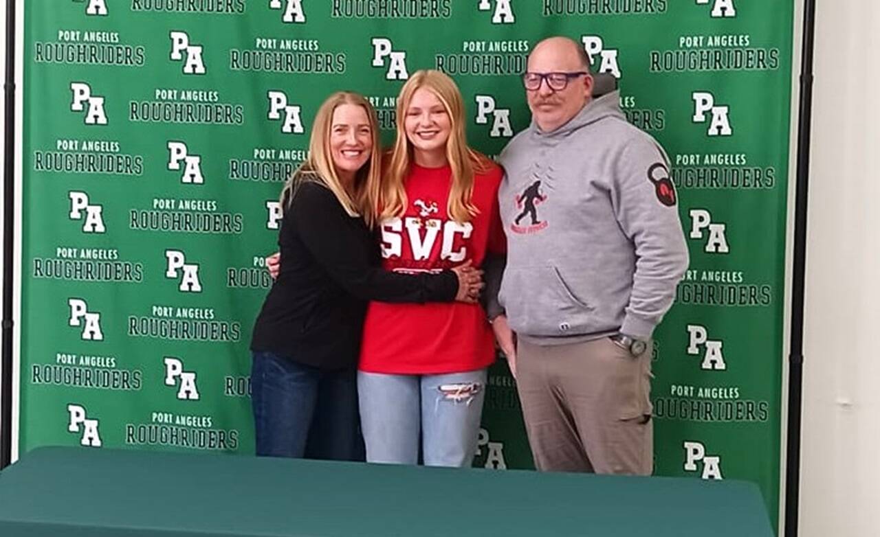 Port Angeles’ Paige Mason on Wednesday signed to play both soccer and basketball for the Skagit Valley College Cardinals. From left are mother Dawn Mason, Paige Mason and father Rob Mason. (Pierre LaBossiere/Peninsula Daily News)