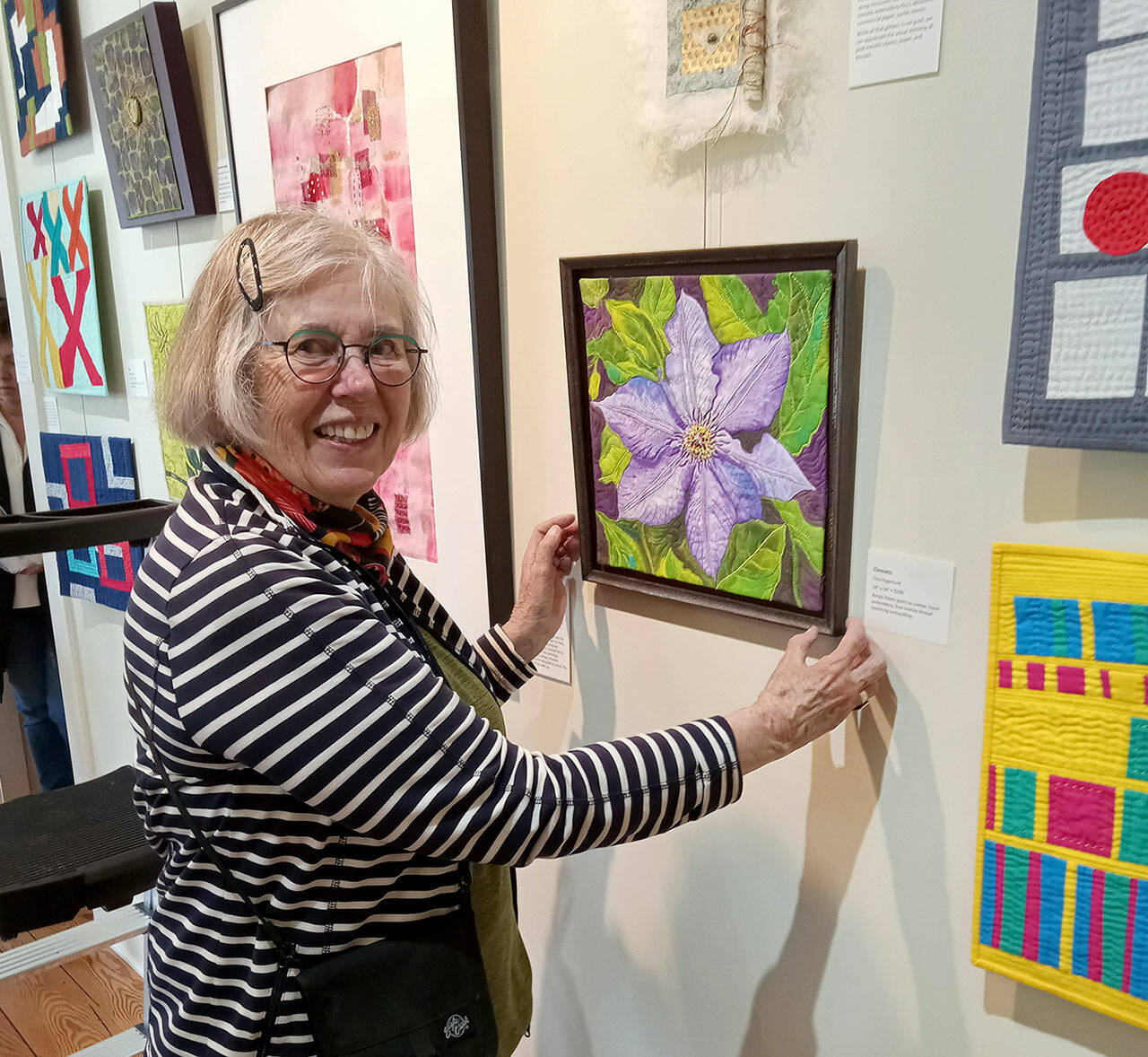 Liisa Fagerlund with a bead-embellished floral image on display at the A. Milligan Gallery on North Sequim Avenue.