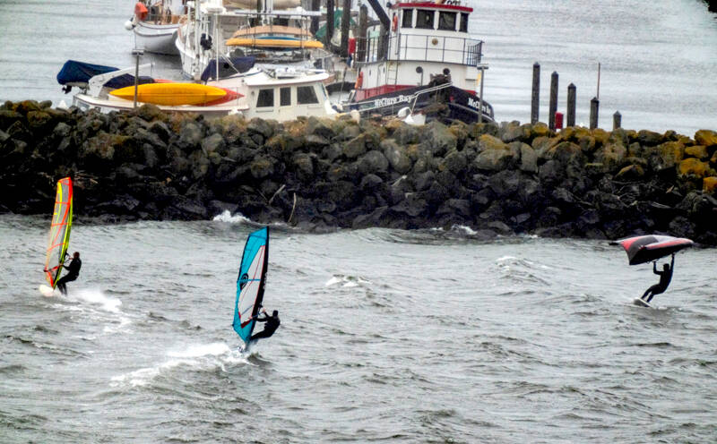 Windsurfers take to the choppy waters of Port Townsend Bay to take advantage of the brisk stormy winds blowing in from the south. By contrast, the calm waters of the Port Townsend Boat Haven Marina can be seen in the background. (Steve Mullensky/for Peninsula Daily News)