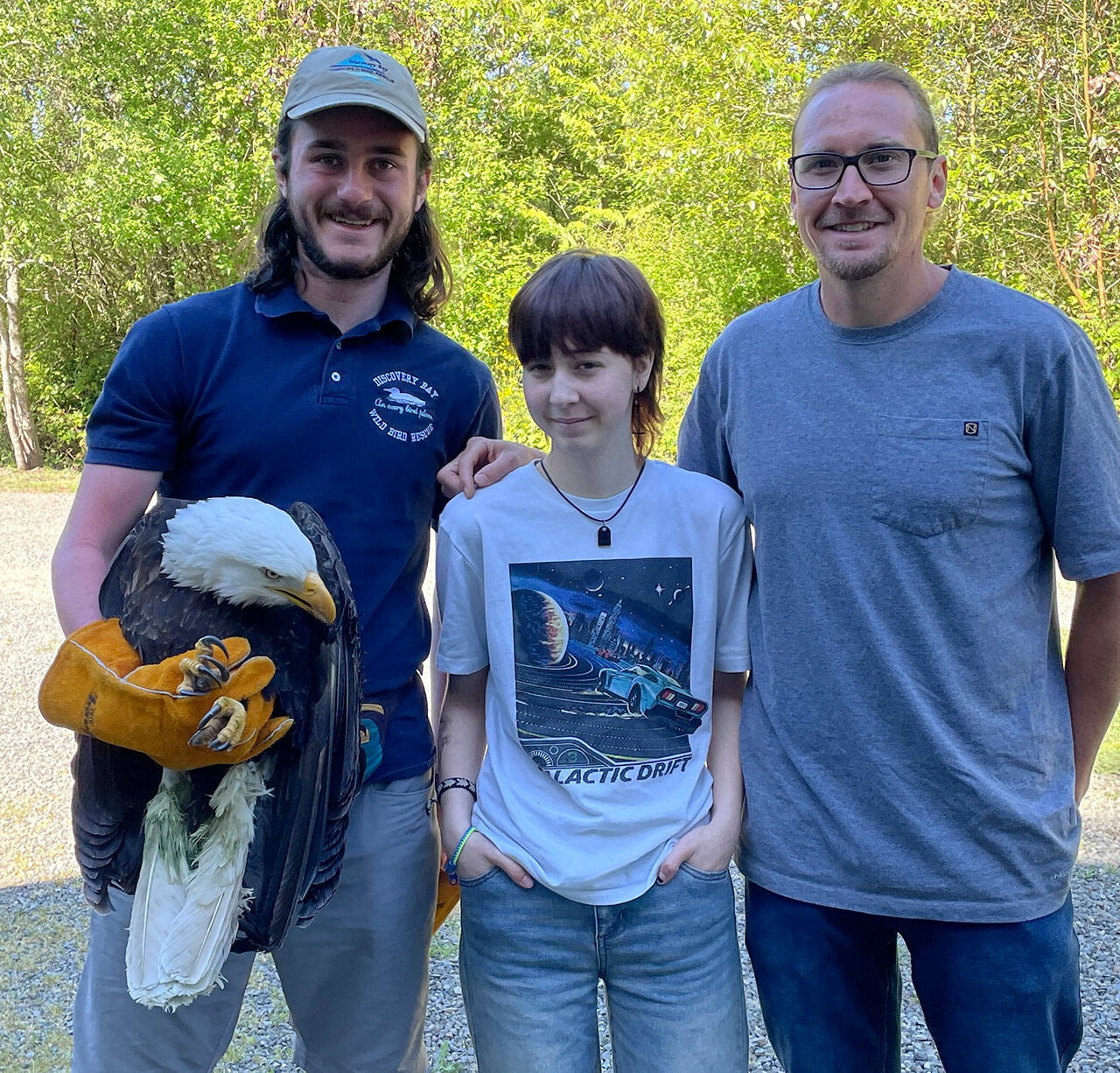 Joseph Molotsky of Discovery Bay Wild Bird Rescue, left, holds an eagle that Annie Espinoza, center, rescued with her friend Kate Burks last month near McDonald Creek. Her uncle, Daniel McMurray, right, drove her to the rescue center the next morning so the bird could be treated. It continues to be treated for a possible hip and/or spinal injury. (Dungeness Bay Wild Bird Rescue)