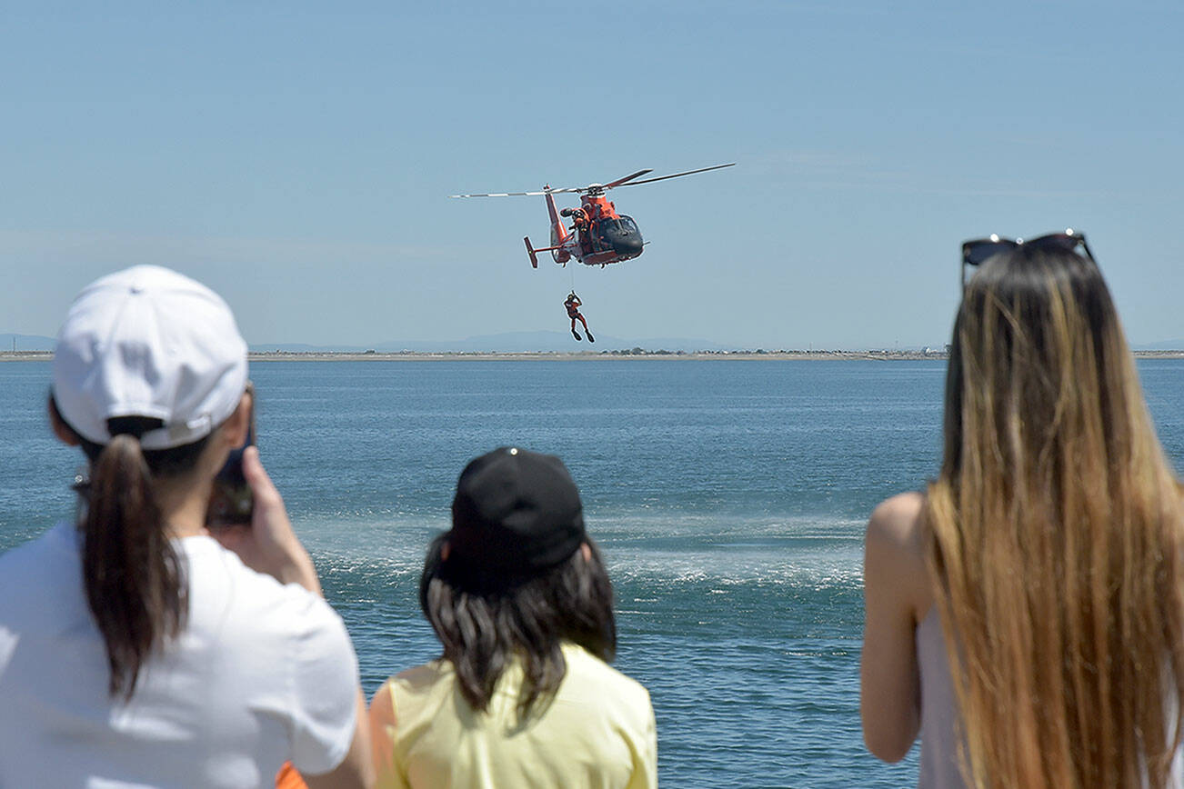 Spectators watch a U.S. Coast Guard rescue drill in Port Angeles Harbor during Saturday’s Maritime Festival along the Port Angeles waterfront. The two-day event, hosted by the Port of Port Angeles, served as a showcase for boating and the maritime trades. (Keith Thorpe/Peninsula Daily News)