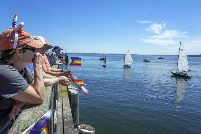 Steve Mullensky/for Peninsula Daily News
Spectators watch as a parade of boats passes by at the start of the Pride event at Pope Marine Park in Port Townsend on Saturday.