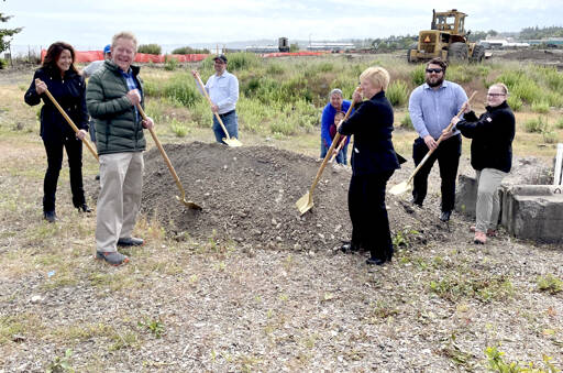 Port of Port Angeles commissioners Colleen McAleer, left, and Connie Beauvais, third from right, put shovels in the dirt at a groundbreaking ceremony on Sunday for the port’s Marine Trade Center on the former Peninsula Plywood site on Marine Drive. Development of the 18-acre site will include installing utilities, paving and grading. Work is anticipated to be completed before the end of the year. The $10 million project was funded with a $7.3 million grant from the U.S. Economic Development Administration and $3.87 million from the port. From left to right, McAleer; Port Angeles City Manager Nathan West (partially hidden); Clallam County Commissioner Randy Johnson; Clallam County Commissioner Mike French; Lower Elwha Klallam Tribe Chairwoman Frances Charles; Beauvais; Michael Snodgrass, Olympic Peninsula Outreach Director for U.S. Sen. Maria Cantwell; and Haley Schanne, Director of Outreach for 6th Congressional District U.S. Rep. Derek Kilmer. (Paula Hunt/Peninsula Daily News)
