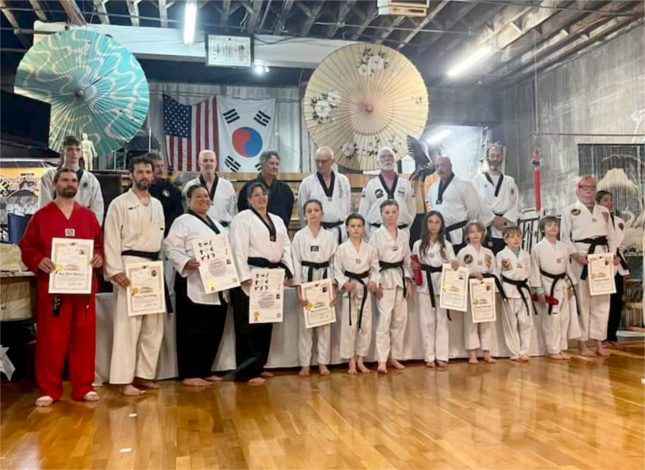 Students received new belts and moved up in belts at a White Crane Taekwondo tournament held in Port Angeles this past weekend. Front row, from left, Ray Mickey, who moved up to second level black belt; new black belts Shaun Parker, Joy Rosenblum and Angela Holcott from Poulsbo, Maverick Parker, Jasper Fleming, Atticus Fleming, Inka Burke, Margret Trowbridge, Triton Stone, Lucas Beauvais and Kirsten Neilsen, all of Port Angeles. The testing board was Ron Mondragon of Seattle, Andrea Pirzio-Biroli of Mercer Island, John Kahler of Seattle, Don Wootten of Seattle, Grandmaster Robert Nicholls of Port Angeles and Todd Norcross of Poulsbo.