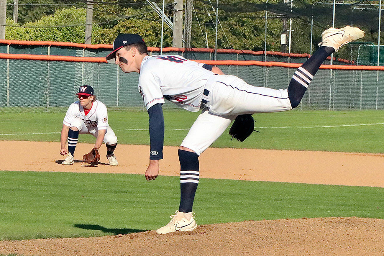 Wilder Senior pitcher Rylan Politika throws to the plate as his teammate at third base, Josiah Gooding waits the results of the pitch. Politika was part of a 13-strikeout, four-hit shutout as Wilder Senior won 3-0. (Dave Logan/for Peninsula Daily News)