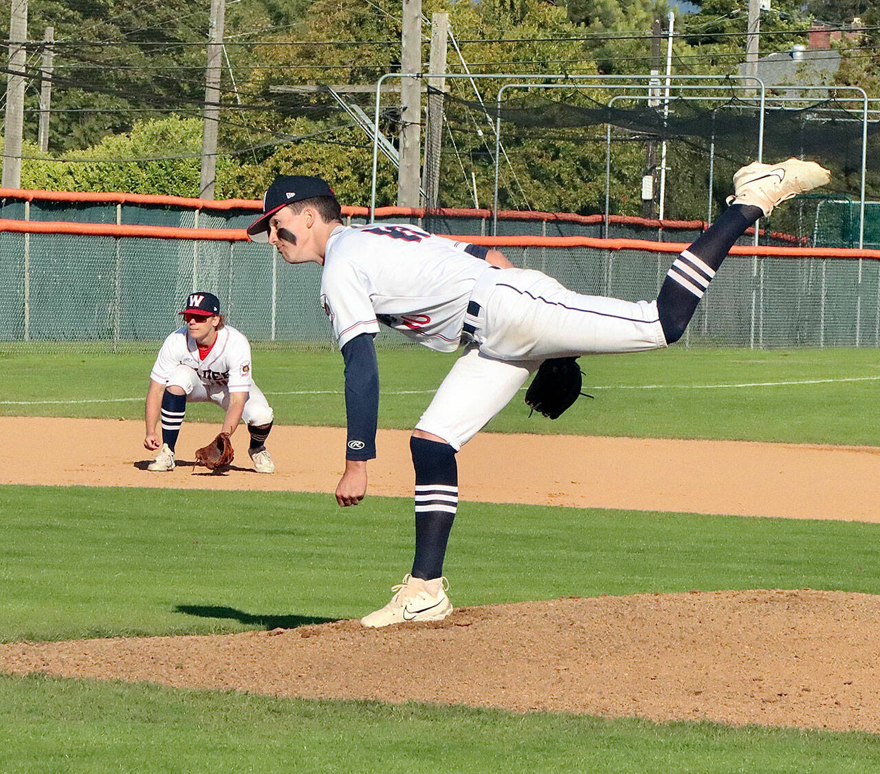 Wilder Senior pitcher Rylan Politika throws to the plate as his teammate at third base, Josiah Gooding waits the results of the pitch. Politika was part of a 13-strikeout, four-hit shutout as Wilder Senior won 3-0. (Dave Logan/for Peninsula Daily News)