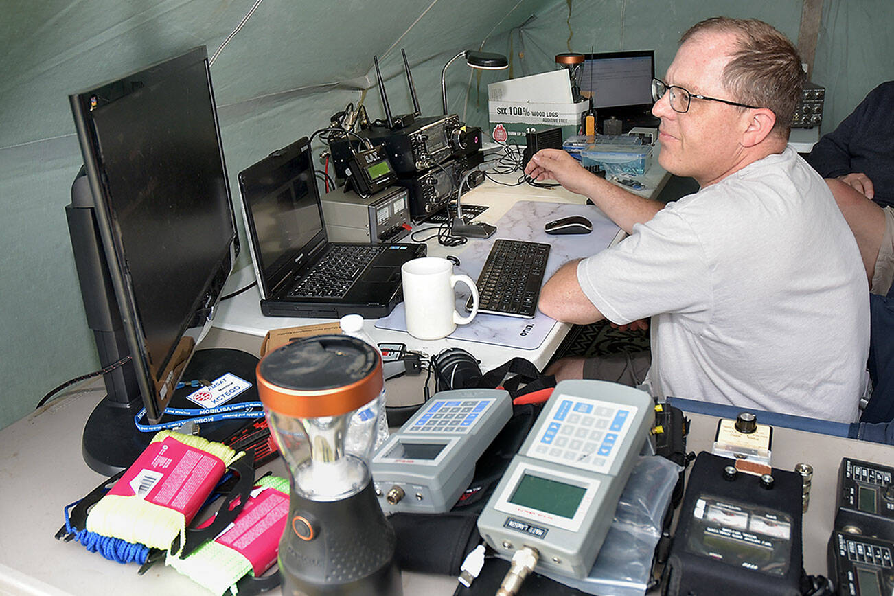 Matt Larson of Sequim, who uses the radio call sign KC7EQO, tunes into a ham radio satellite during Saturday’s Radio Field Day at the Clallam County Fairgrounds in Port Angeles. The annual event, hosted by the Clallam County Amateur Radio Club, brought together amateur radio operators from around the world in a contest to make as many radio contacts as possible in a 24-hour period as a test of emergency preparedness from remote locations. (Keith Thorpe/Peninsula Daily News)