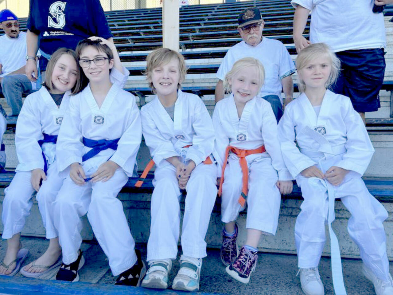 A group of White Crane Martial Arts students rest between performances at a Port Angeles Lefties game at Civic Field. From left, are Sophia Gallon, August Gallon, Noah Larson, Skye Larson and Alexandra Gmazel. (White Crane Martial Arts)