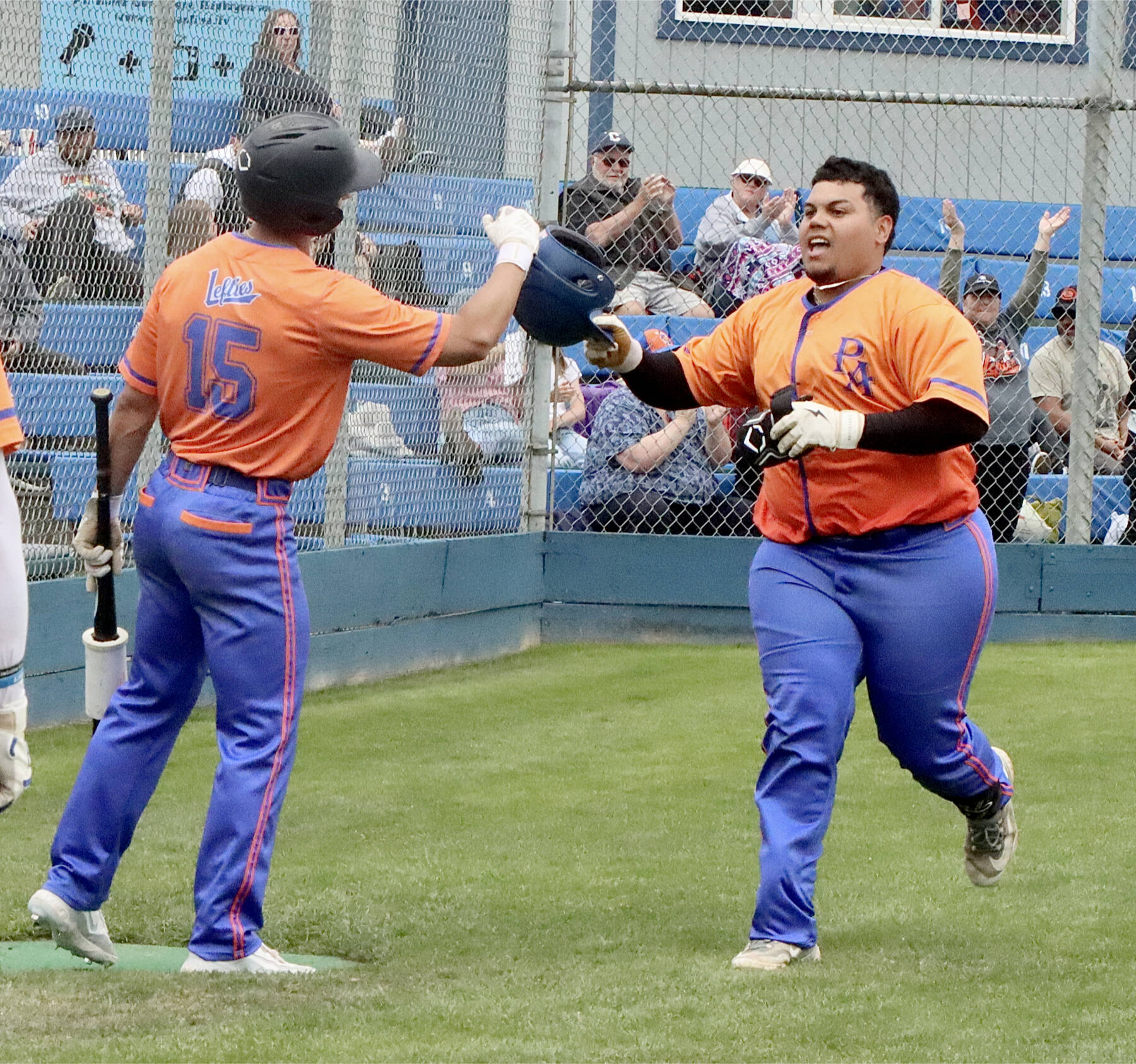 Spencer Dickinson of Saipan is greeted at home plate at Civic Field on Sunday by teammate Zach Blair after hitting a home run for the Port Angeles Lefties. (Dave Logan/for Peninsula Daily News)