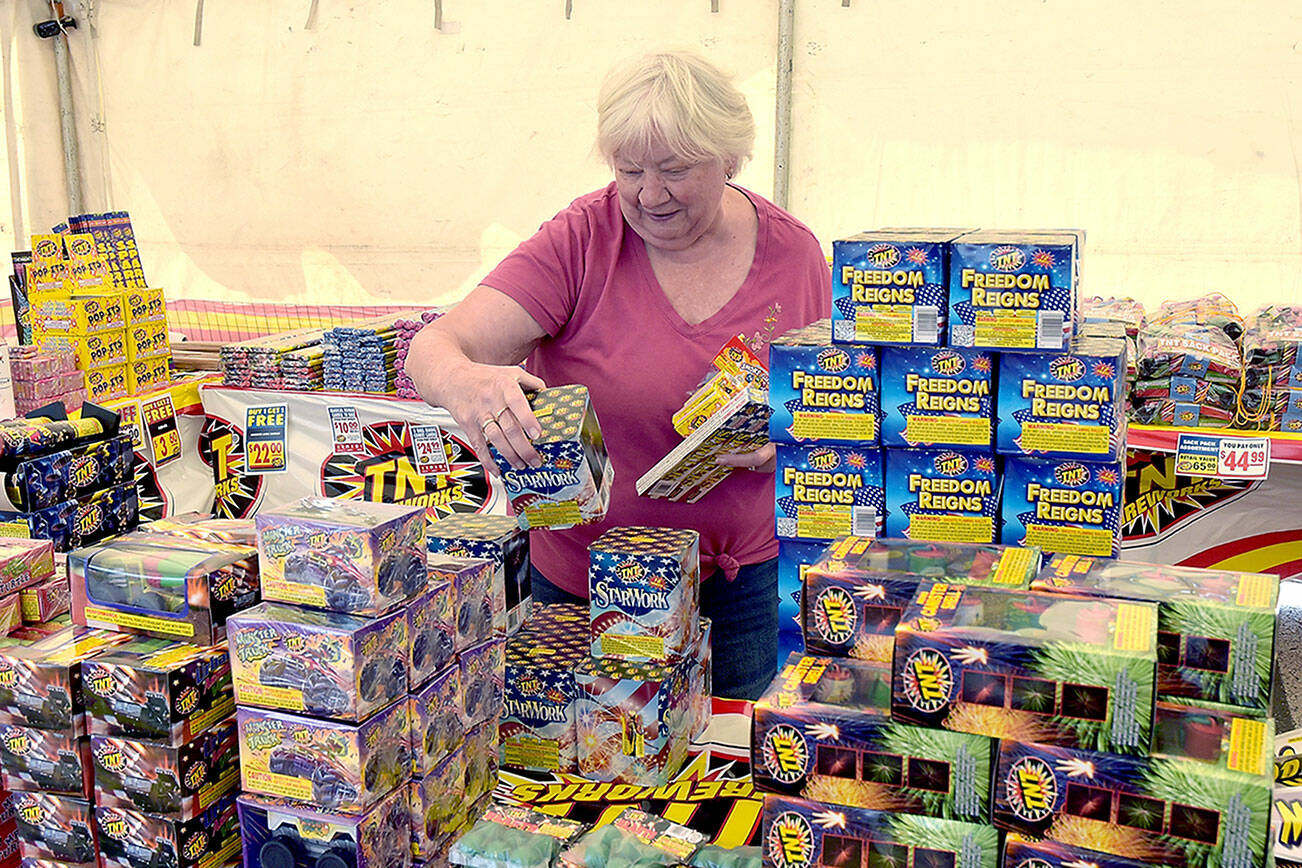 Marie Moran of Port Angeles looks over a selection of fireworks available at the TNT Fireworks stand operated by the Seattle International Christian Church in the parking lot of the Safeway store at 2709 E. Highway 101 near Port Angeles on Tuesday. In Clallam County, the discharge of consumer fireworks are allowed between 9 a.m. and midnight on Thursday for areas east of the Elwha River and at all times west of the Elwha. They are banned in the cities of Port Angeles and Sequim. In Jefferson county, fireworks are banned in the city of Port Townsend and allowed in most other areas with hours limited to 9 a.m. to 11 p.m. today and Friday, and from 9 a.m. to midnight on Independence Day. (Keith Thorpe/Peninsula Daily News)