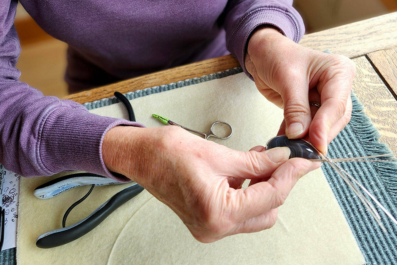 Paulette Hill, a jewelry artist, wire wrapping a Botswana agate cabochon.