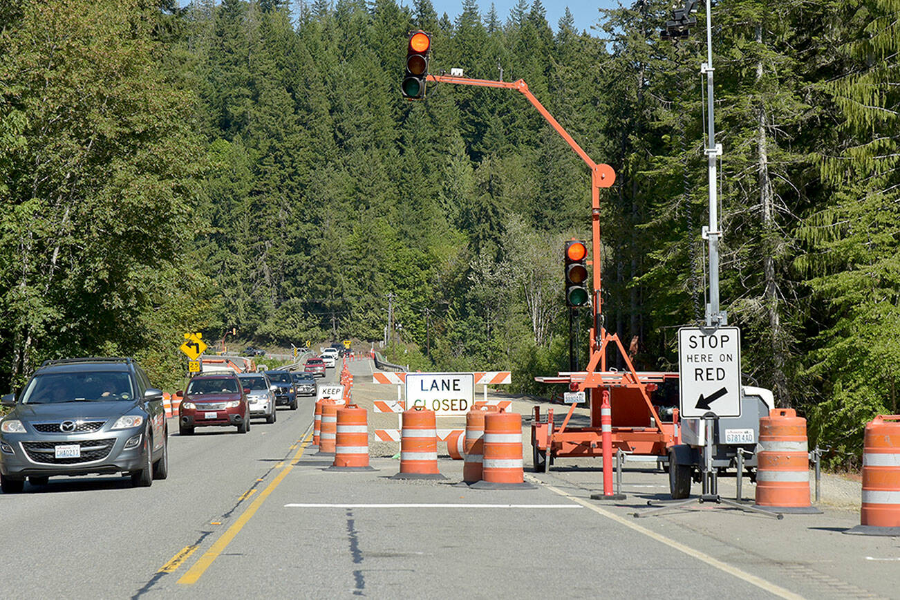 One-way alternating traffic makes its way across the U.S. Highway 101 bridge over the Elwha River southwest of Port Angeles. The bridge is scheduled for a nine-day closure beginning at 6 p.m. Friday through 5 a.m. July 22 as crews connect the new bridge with the old roadway. During the closure, travelers will detour onto state Highways 112 and 113. (Keith Thorpe/Peninsula Daily News)