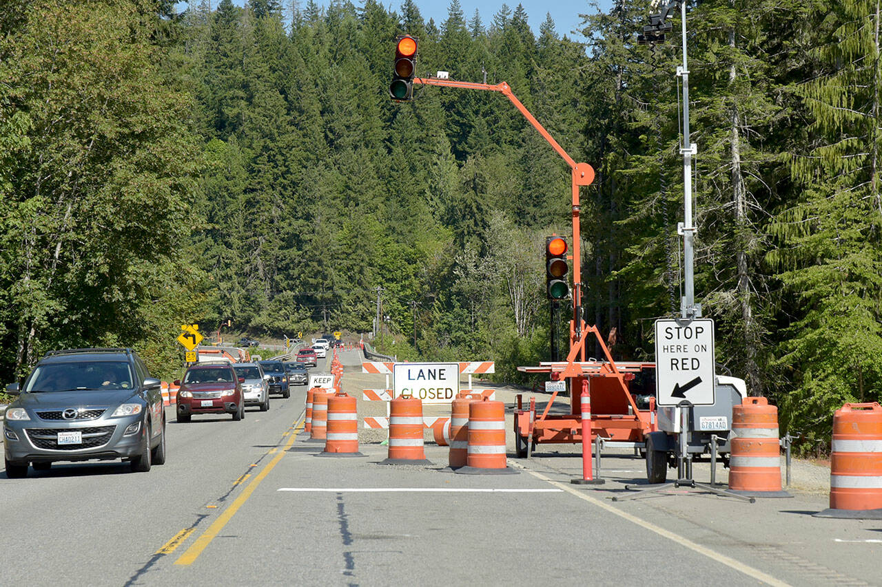 One-way alternating traffic makes its way across the U.S. Highway 101 bridge over the Elwha River southwest of Port Angeles. The bridge is scheduled for a nine-day closure beginning at 6 p.m. Friday through 5 a.m. July 22 as crews connect the new bridge with the old roadway. During the closure, travelers will detour onto state Highways 112 and 113. (Keith Thorpe/Peninsula Daily News)