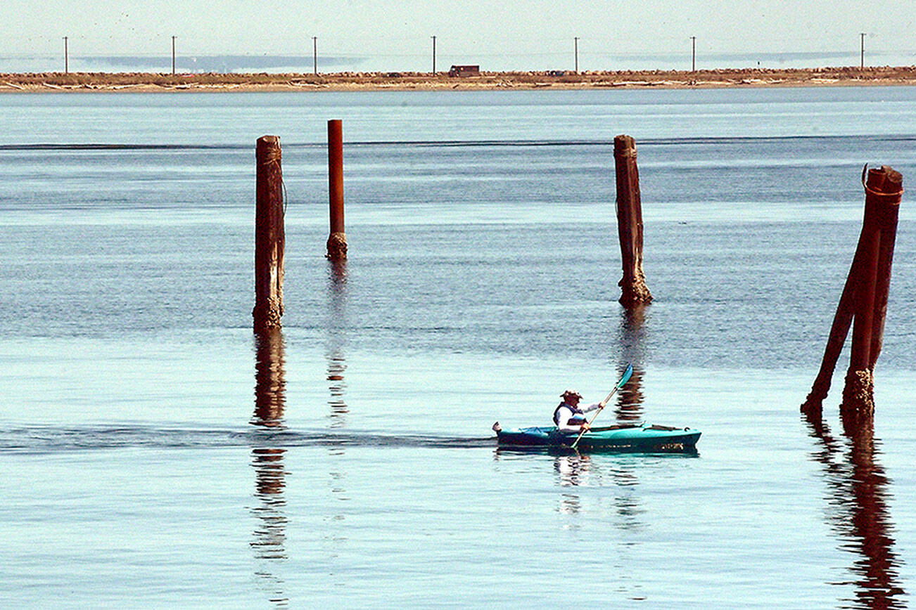 A kayker makes his way between the pilings of a former floating log yard near the entrance to Port Angeles Boat Haven. Pleasant conditions and calm waters are expected across most of the North Olympic Peninsula through the coming weekend. (Keith Thorpe/Peninsula Daily News)