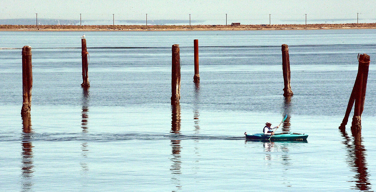 A kayker makes his way between the pilings of a former floating log yard near the entrance to Port Angeles Boat Haven. Pleasant conditions and calm waters are expected across most of the North Olympic Peninsula through the coming weekend. (Keith Thorpe/Peninsula Daily News)