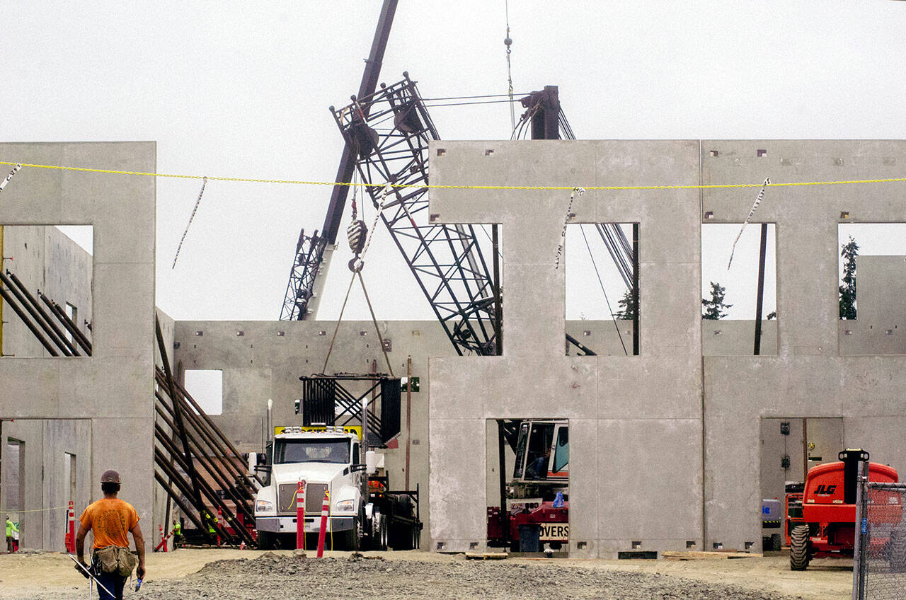 Abbot Construction’s crew responsible for crane lifting the two-story concrete walls pack up as new crew members move in for steel reinforcement on Monday. (Elijah Sussman/Peninsula Daily News)