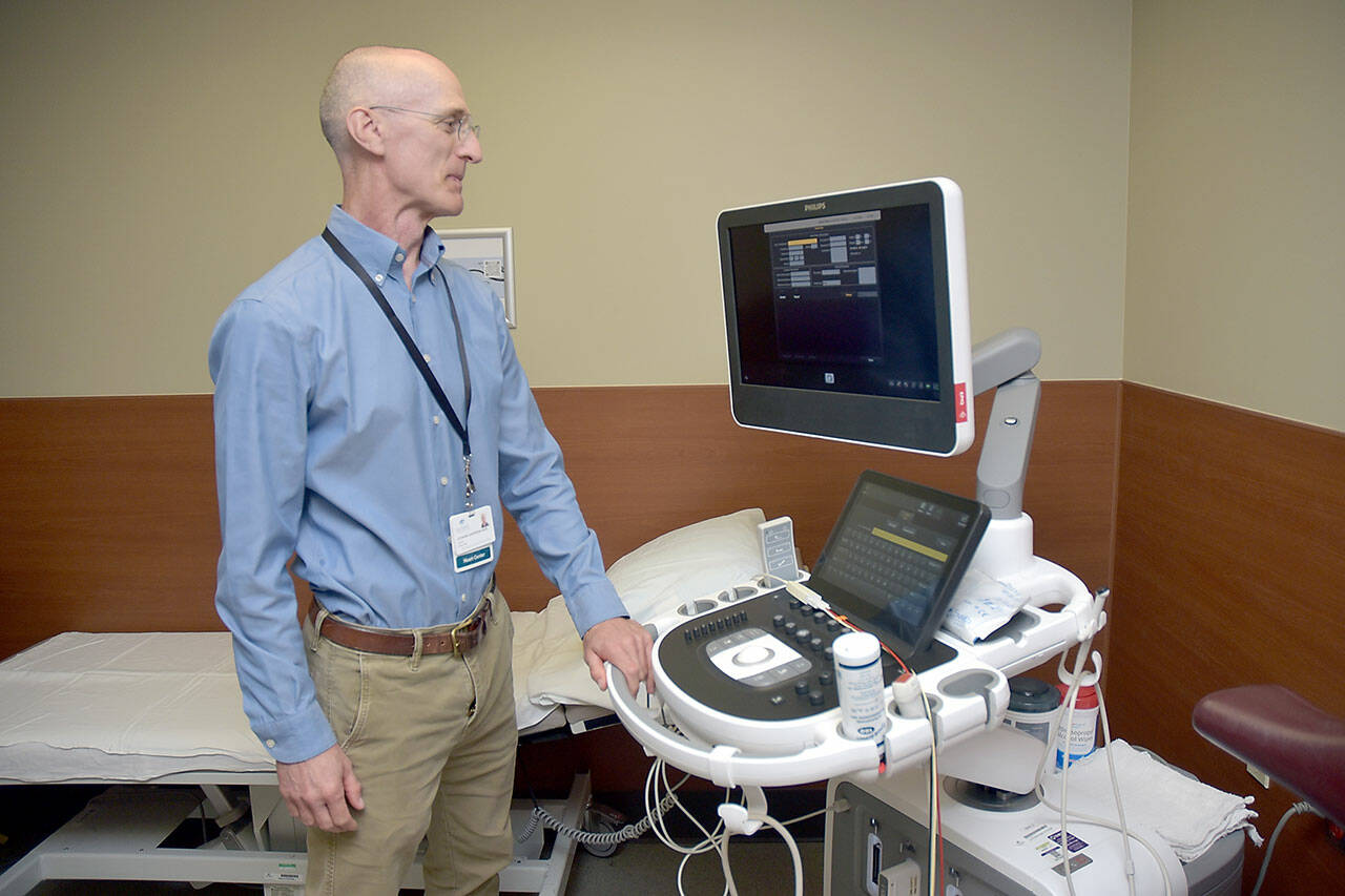 Olympic Medical Heart Center director Leonard Anderson examines a new echocardiograph at the Port Angeles hospital facility. (Keith Thorpe/Peninsula Daily News)