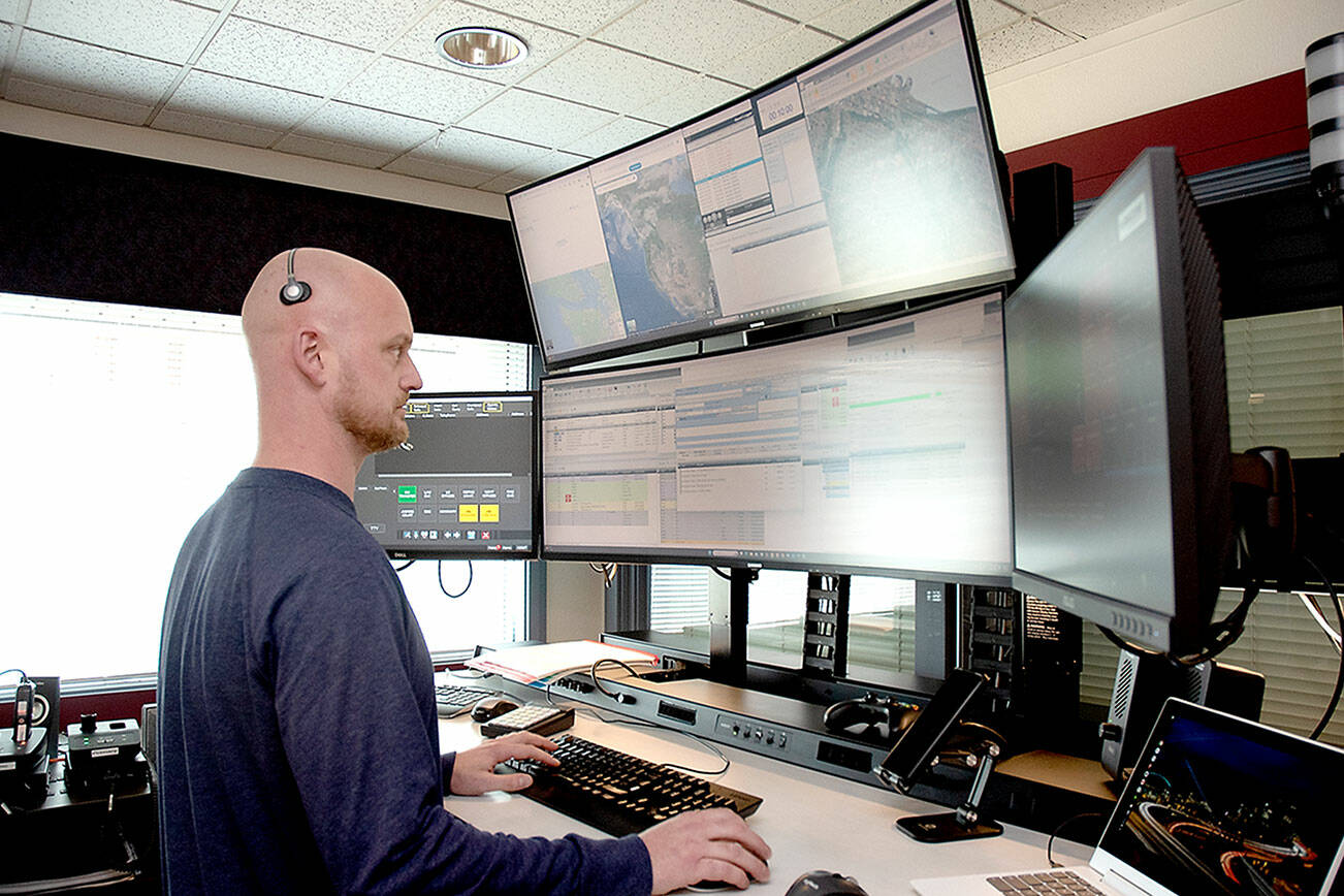 KEITH THORPE/PENINSULA DAILY NEWS
Communications officer Ian Harrington oversees a bank of computer screens at the Peninsula Communications emergency dispatch center on Wednesday in Port Angeles.