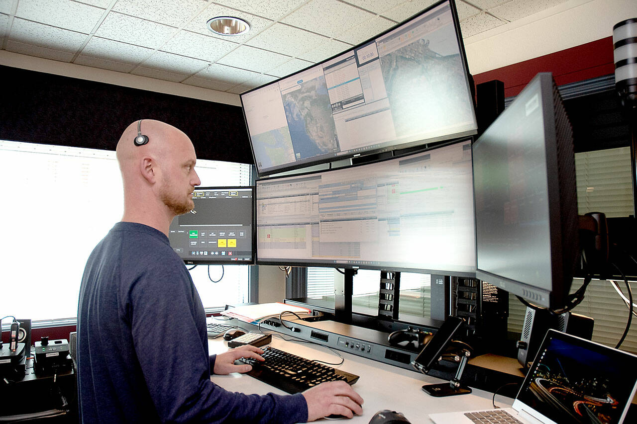 Communications officer Ian Harrington oversees a bank of computer screens at the Peninsula Communications emergency dispatch center on Wednesday in Port Angeles. (KEITH THORPE/PENINSULA DAILY NEWS)