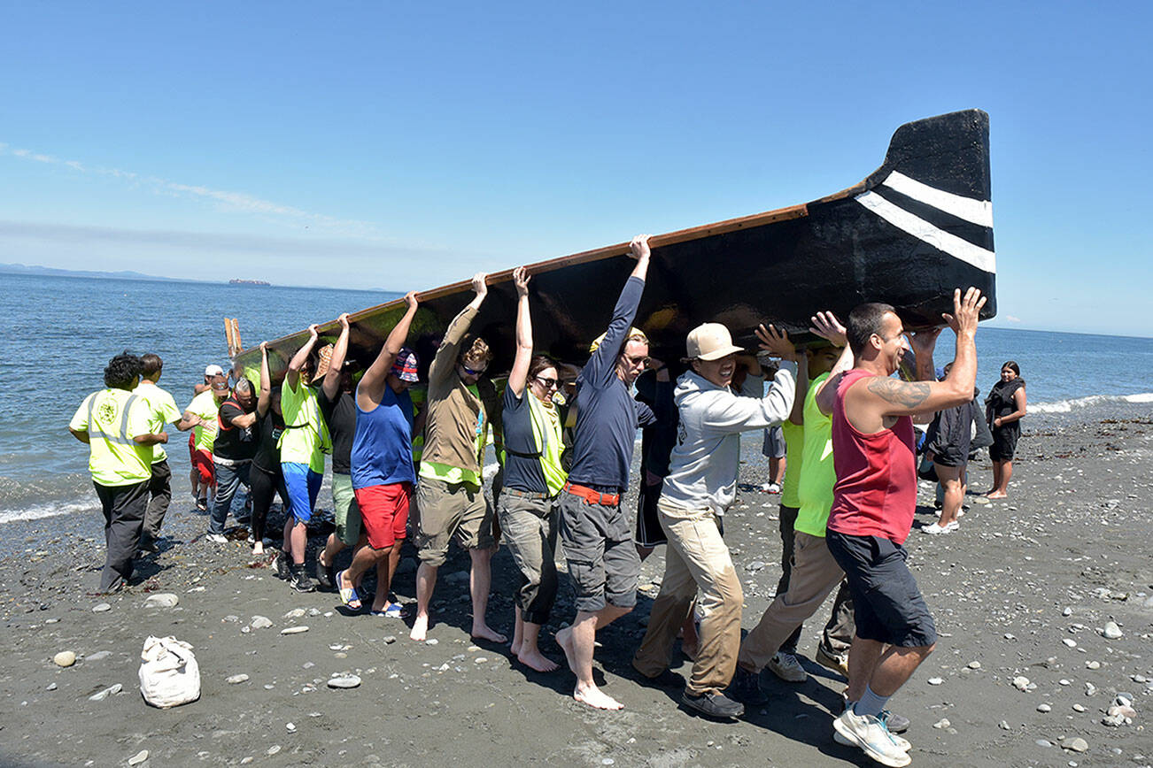 KEITH THORPE/PENINSULA DAILY NEWS
A canoe from Ahousaht First nations of western Vancouver Island is hauled ashore by volunteers on Tuesday on Lower Elwha Clalllam land near the mouth of the Elwha River west of Port Angeles.