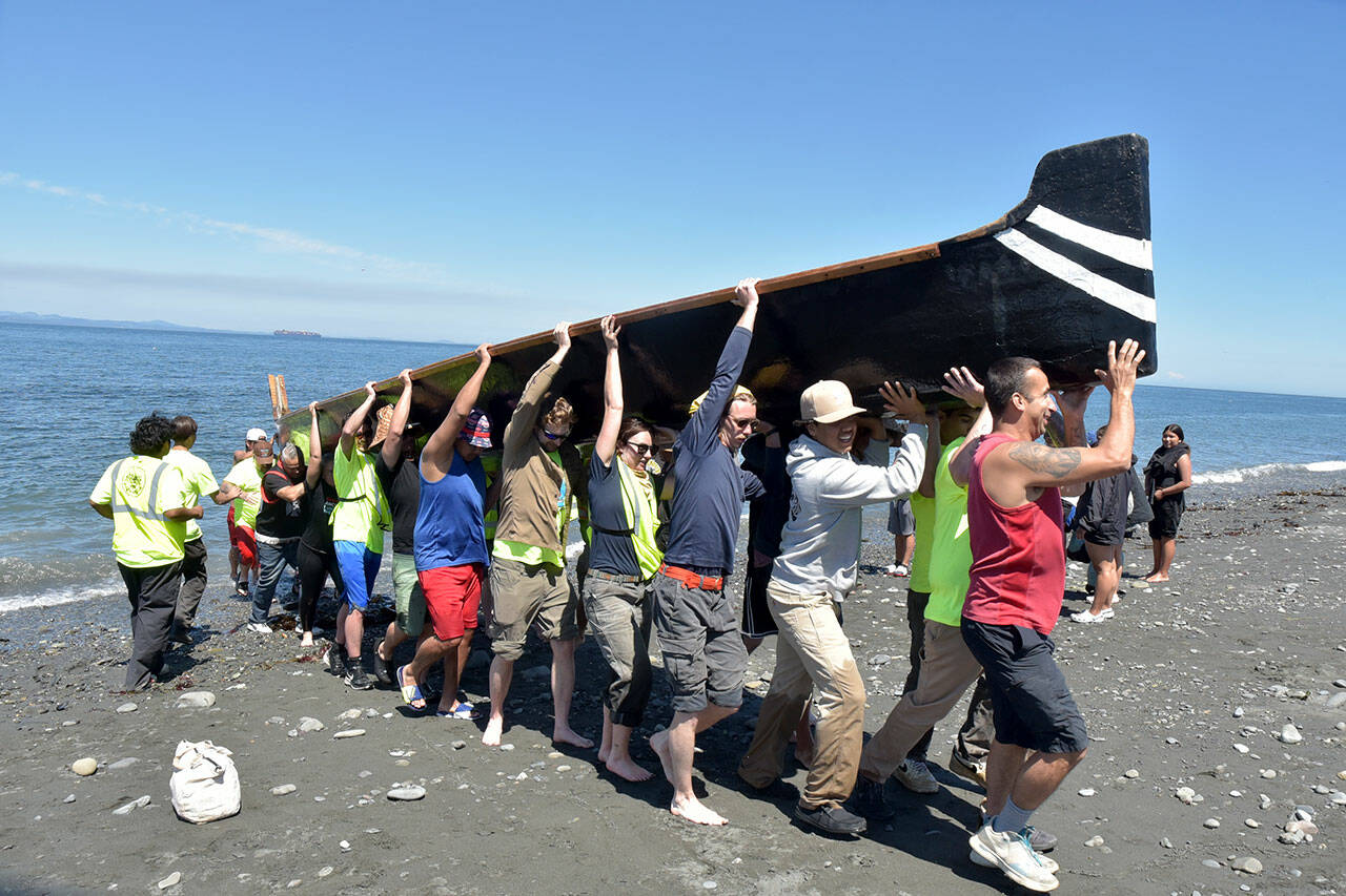 A canoe from Ahousaht First Nations of western Vancouver Island is hauled ashore by volunteers Tuesday on Lower Elwha Klallam land near the mouth of the Elwha River west of Port Angeles, a port of call and point of welcome for haulers taking part in Power Paddle to Puyallup Youth Canoe Journey 2024. Tribal groups from across southern Canada and the Pacific Northwest are taking part in the journey, which culminates with dozens of tribes gathering on Puyallup territory in Tacoma on Aug. 1.