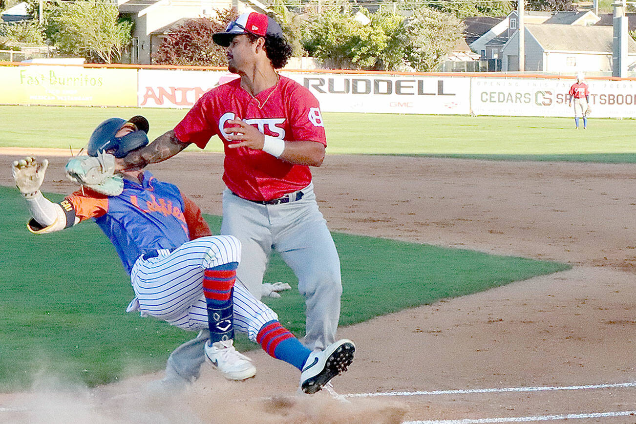 Port Angeles' Ethan Kodama collides with Victoria HarbourCat first baseman Michelle Artzberger after hitting a dribbler along the first-base line. Kodama was down on the ground for half a minute but got up and finished the game. (Dave Logan/for Peninsula Daily News)