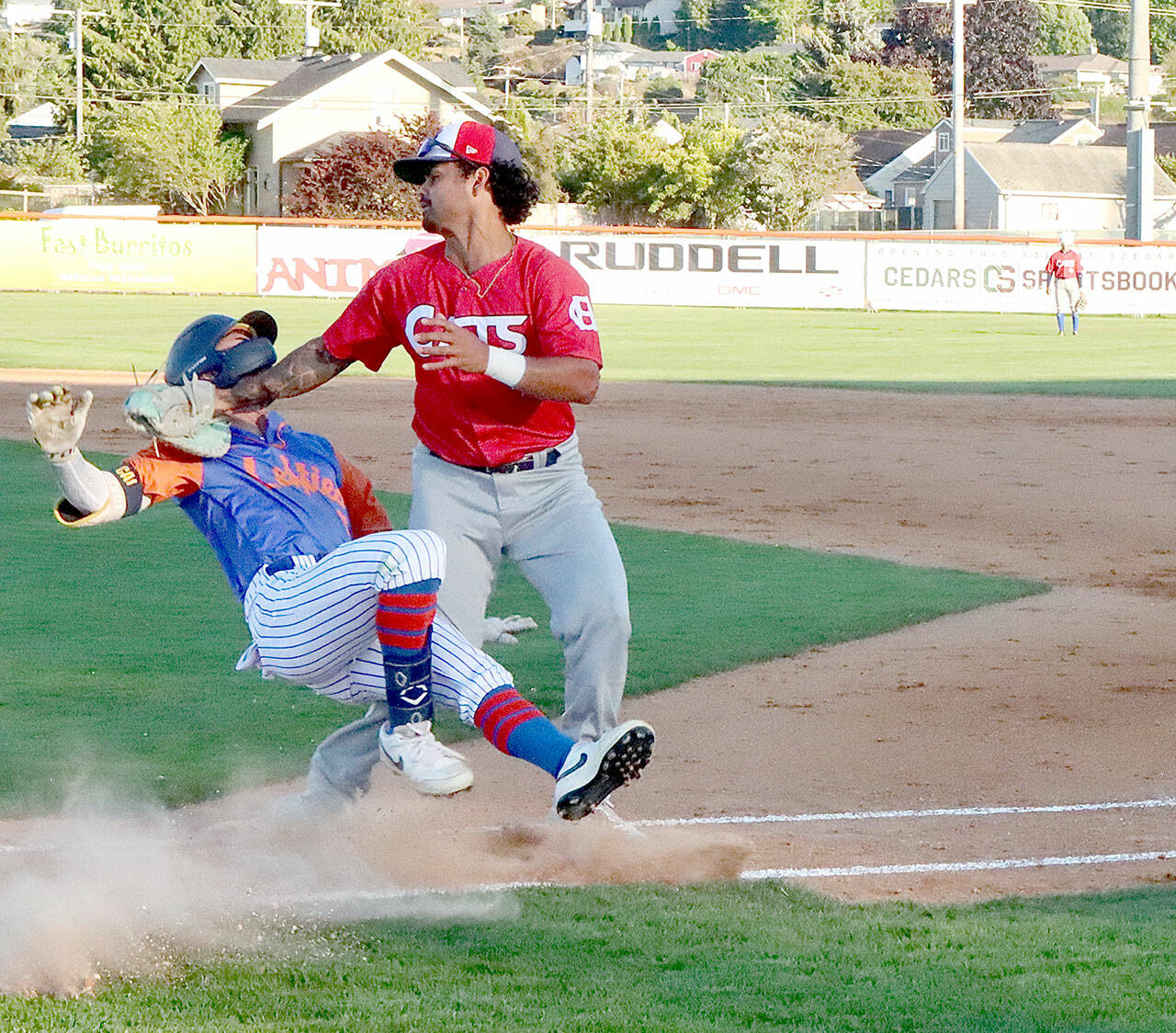 Port Angeles’ Ethan Kodama collides with Victoria HarbourCat first baseman Michelle Artzberger after hitting a dribbler along the first-base line. Kodama was down on the ground for half a minute but got up and finished the game. (Dave Logan/for Peninsula Daily News)