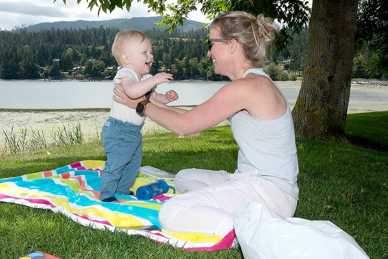 KEITH THORPE/PENINSULA DAILY NEWS
Jamie Nautsch of Sequim plays with her son Christian Nautsch, 1, on the lawn overlooking Sequim Bay at John Wayne Marina on Thursday. Summer-like weather made for a pleasant day next to the water.