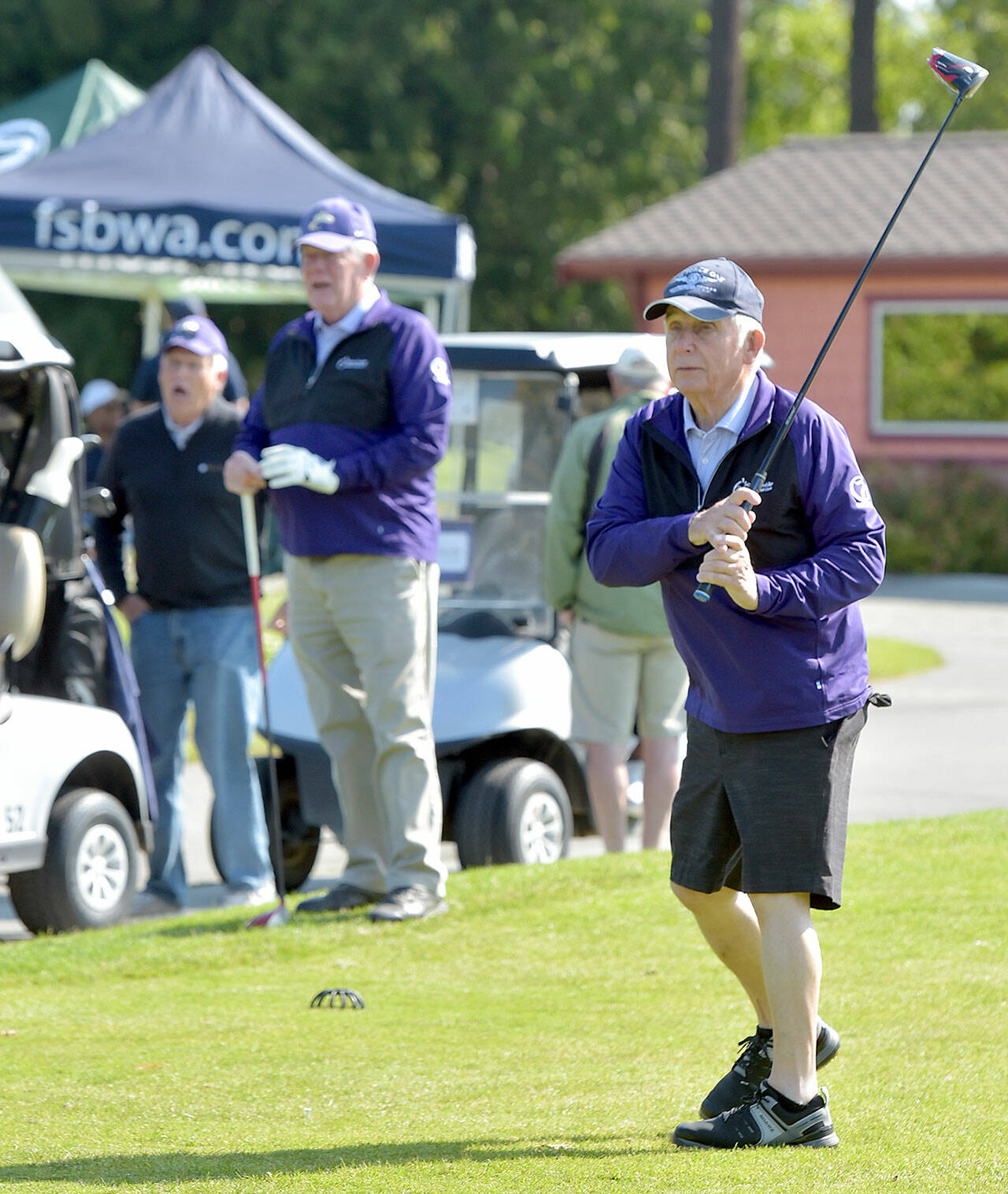 KEITH THORPE/PENINSULA DAILY NEWS John Raske of Port Angeles, right, tees off on the first hole at the Cedars at Dungeness during Friday’s Sonny Sixkiller Celebrity Golf Classic as teammates George Wood, left, and Gary Reidel, both of Port Angeles, watch his drive. Nearly 40 University of Washington Huskies athletes and celebreties, including Sixkiller, took part in the tournament, which raises funds for the Olympic Medical Center Foundation.