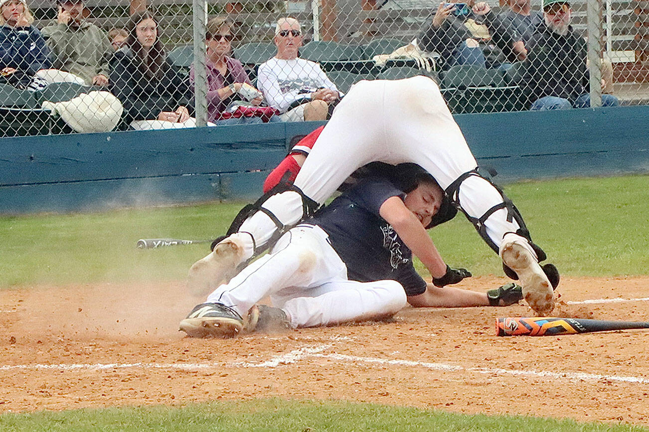 Wilder Senior's Braydan White slides underneath the West Plains Cannons catcher at Civic Field on Monday night, tagging up and trying to score on a fly ball. White was called out at home. (Dave Logan/for Peninsula Daily News)