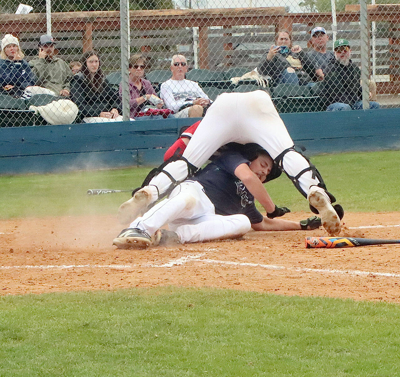 Wilder Senior’s Braydan White slides underneath the West Plains Cannons catcher at Civic Field on Monday night, tagging up and trying to score on a fly ball. White was called out at home. (Dave Logan/for Peninsula Daily News)