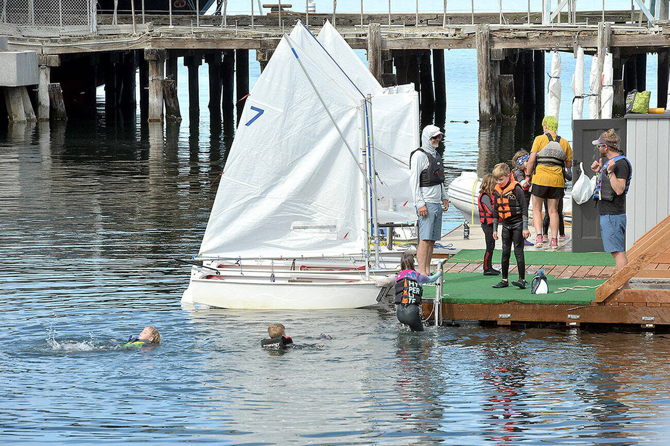 Youngsters taking part in the Community Boating Program at the Port Angeles Yacht Club cavort in the water after an afternoon sailing session on Thursday in Port Angeles Harbor. The program, operated in conjunction with the yacht club and the Port of Port Angeles, gives youths and adults an opportunity to learn boating and sailing from certified instructors. (Keith Thorpe/Peninsula Daily News)
