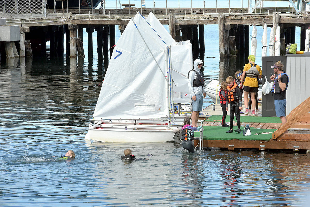 Youngsters taking part in the Community Boating Program at the Port Angeles Yacht Club cavort in the water after an afternoon sailing session on Thursday in Port Angeles Harbor. The program, operated in conjunction with the yacht club and the Port of Port Angeles, gives youths and adults an opportunity to learn boating and sailing from certified instructors. (Keith Thorpe/Peninsula Daily News)