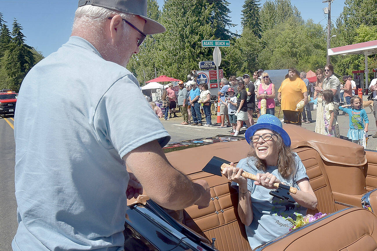 Stephanie Fuscher receives a ceremonial key to the city from Joyce Daze festival chairman John Kent, who took on the honor of being Joyce “mayor” for the day. (Keith Thorpe/Peninsula Daily News)