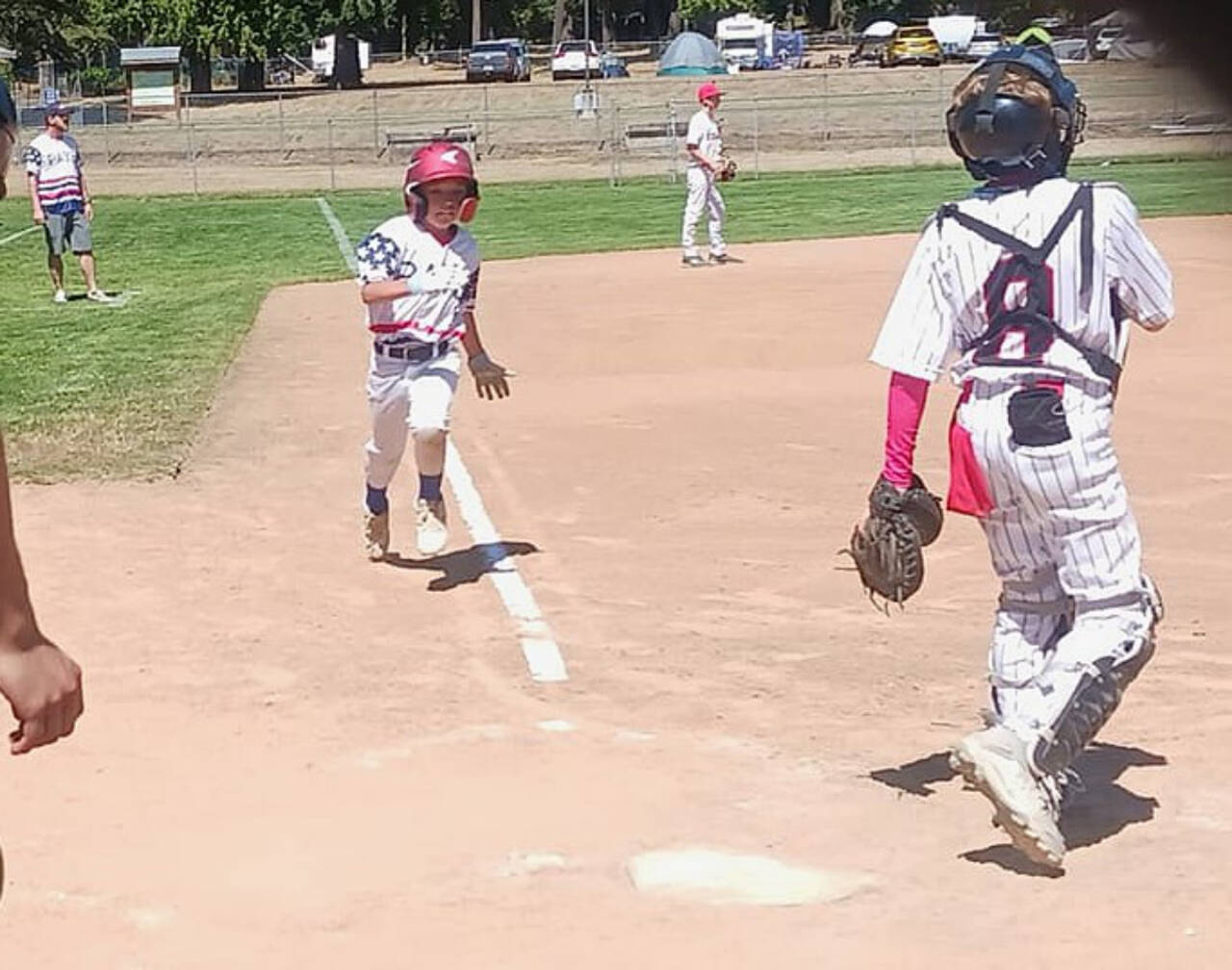 The Port Angeles Youth Baseball team's Liam "Frosty" Grice comes home to score on a groundout during the 25th annual Dick Brown tournament at the Lincoln Park ballfields Saturday. A total of 12 teams attended the tournament for 18 games over two days. (Pierre LaBossiere/Peninsula Daily News)