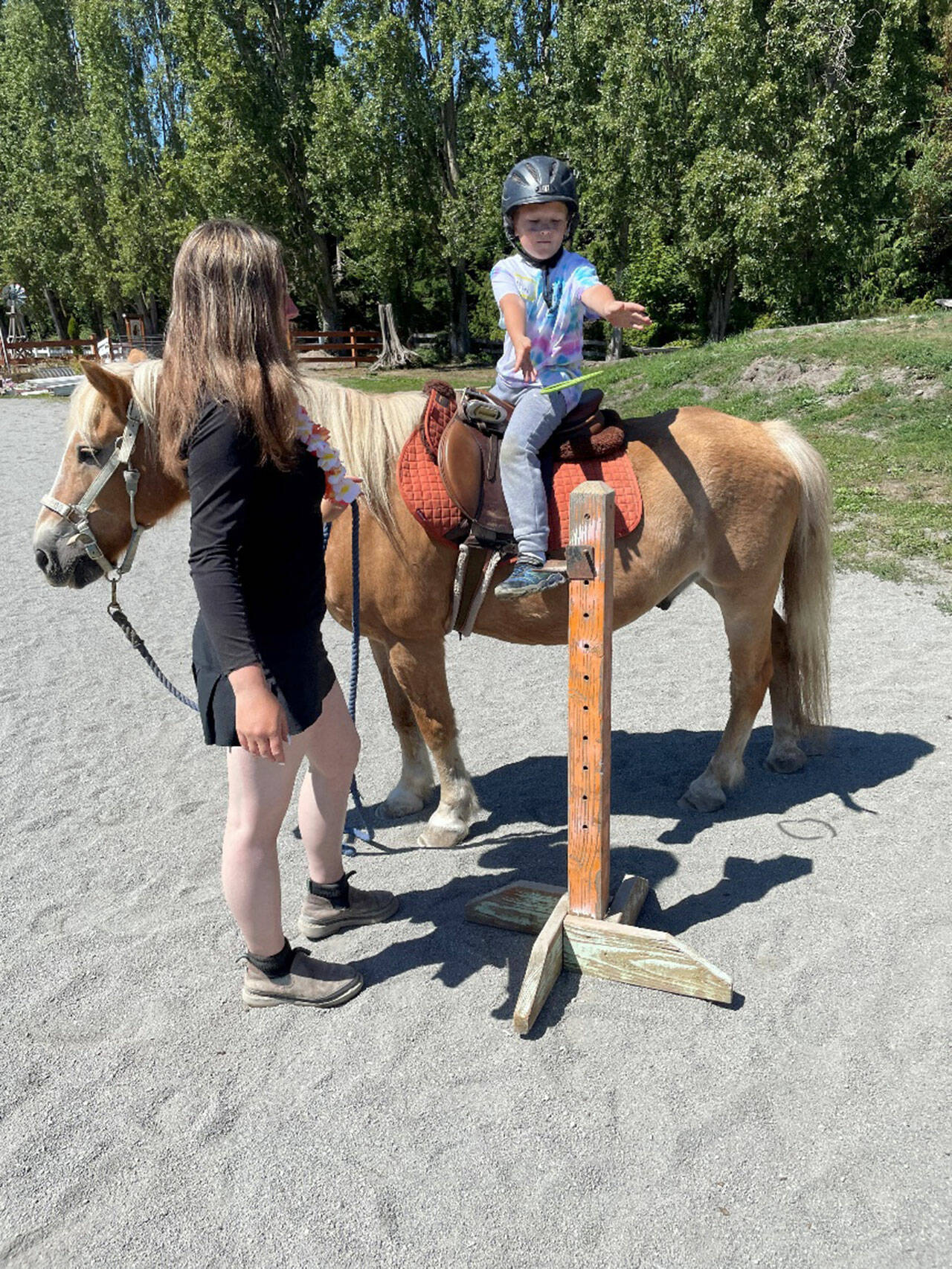 50 young ones signed up to take part in Fox-Bell Farm Training’s Hawaiian themed Kids Camp last weekend, including McCoy Sprenger, 7, on Moon, who played a ring toss game as instructor Sofie Feik looked on. (Photo by Mike Sprenger)